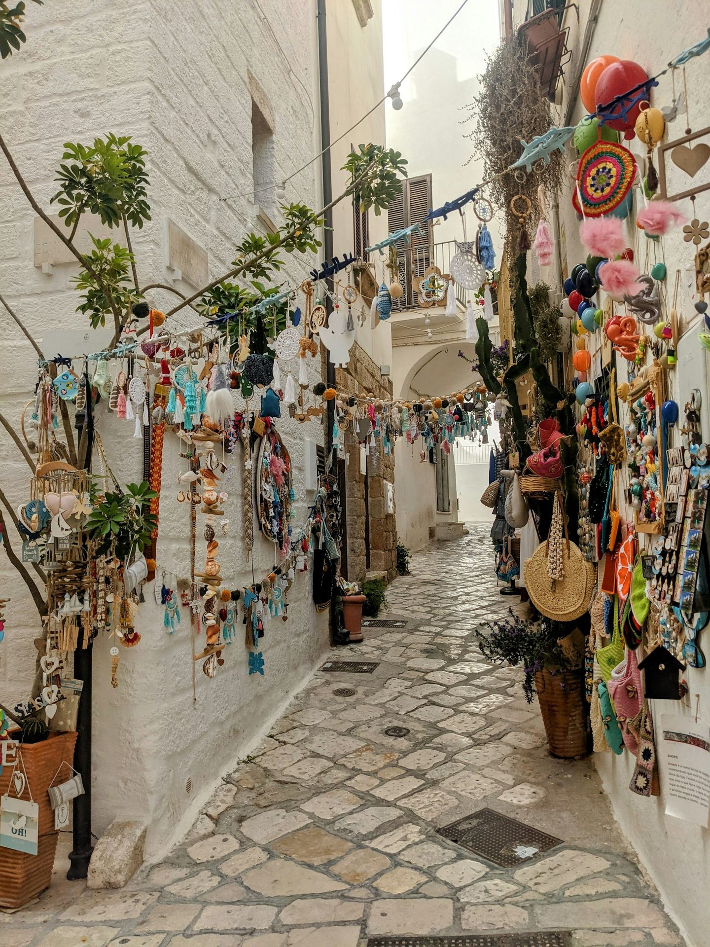 a narrow alley way with a bunch of items hanging on the wall